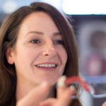 optometrist fitting glasses on patient